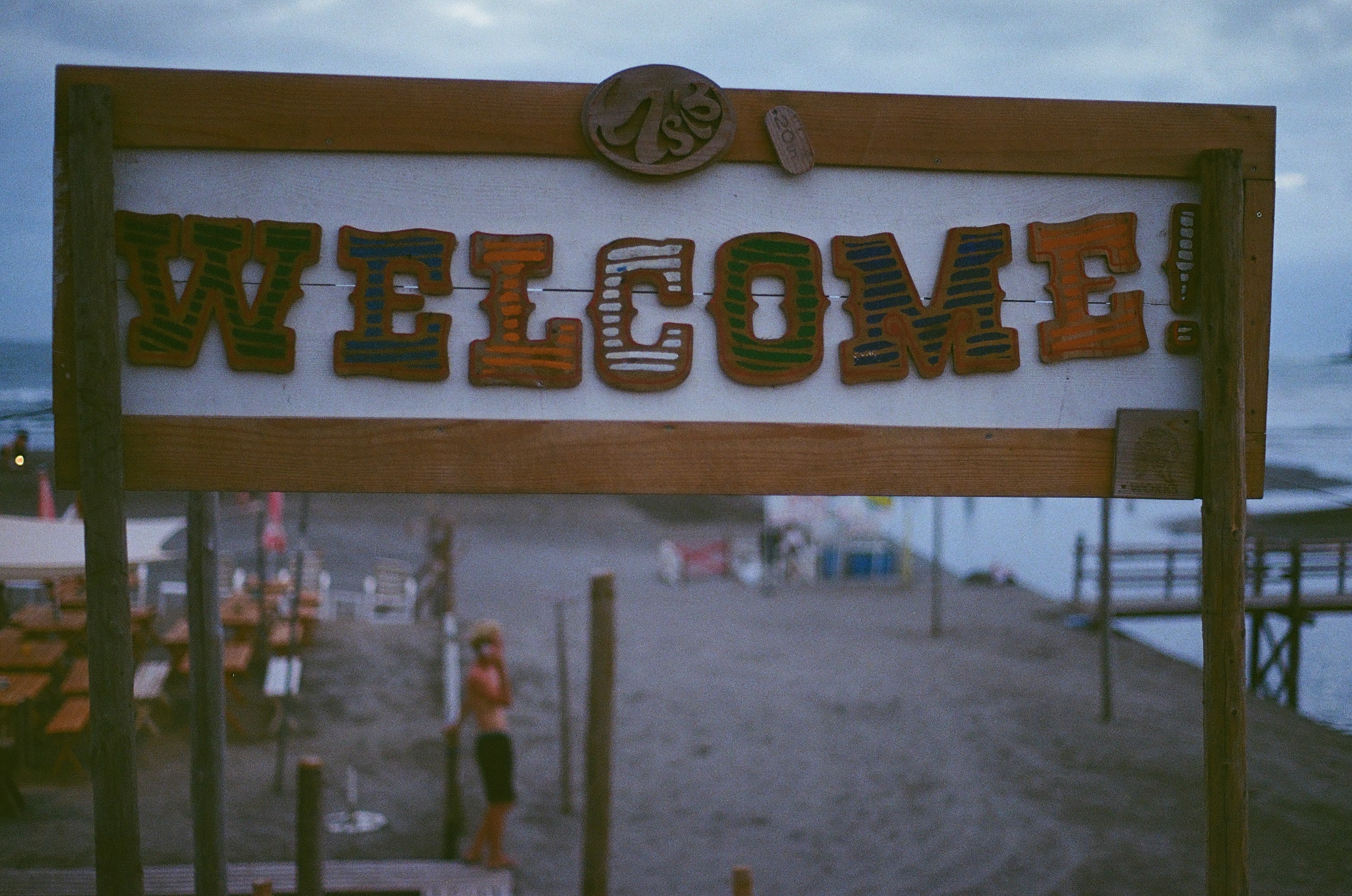 A hand-painted welcome sign beside a coastal path