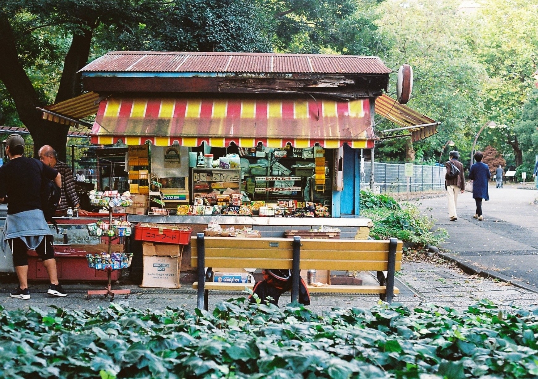 An old park kiosk beneath a red and yellow awning