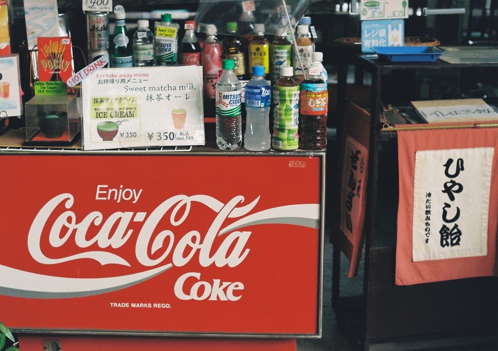 A red drink counter framed by Coca-Cola signs