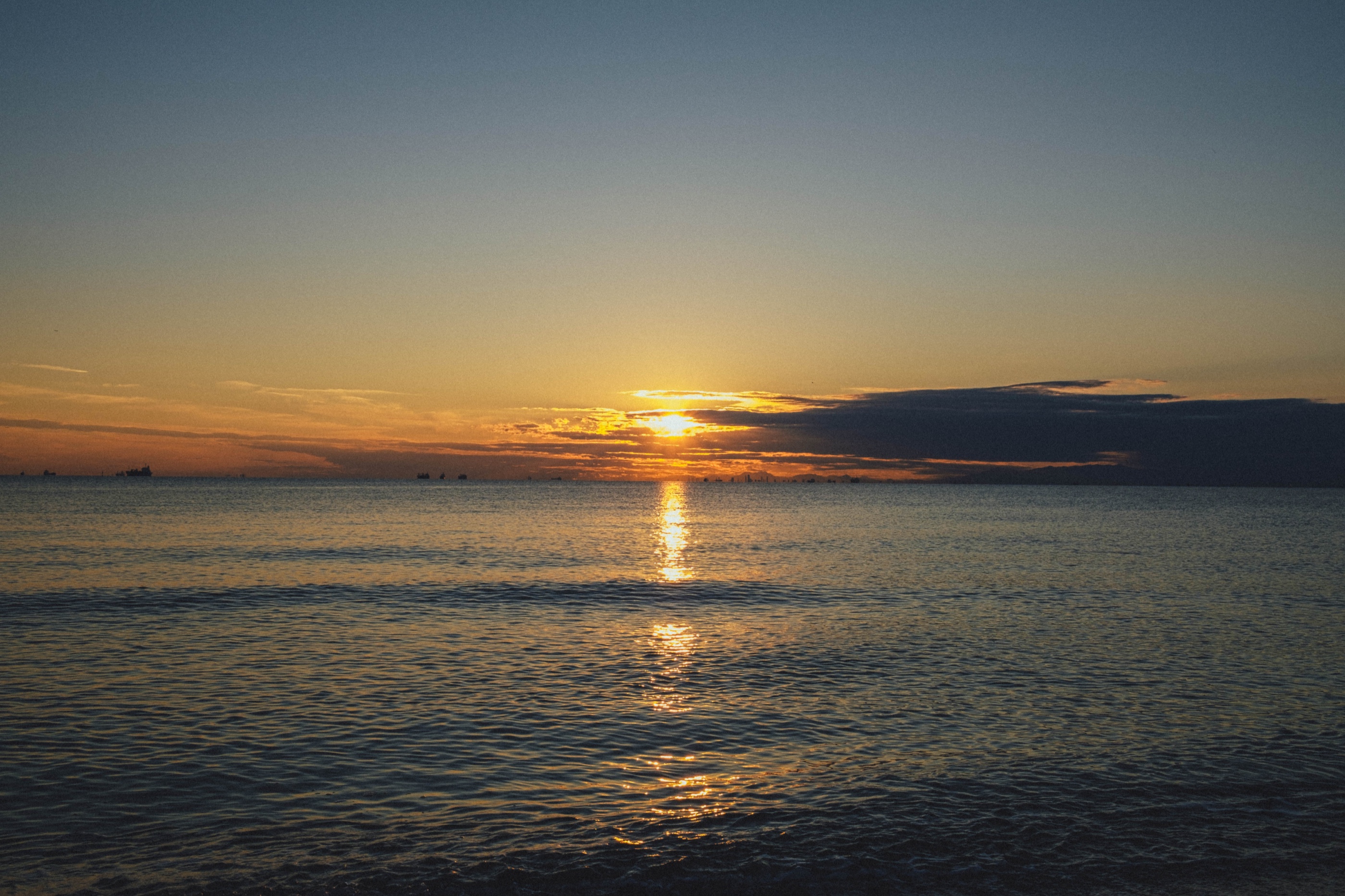 The setting sun reflected across a calm sea